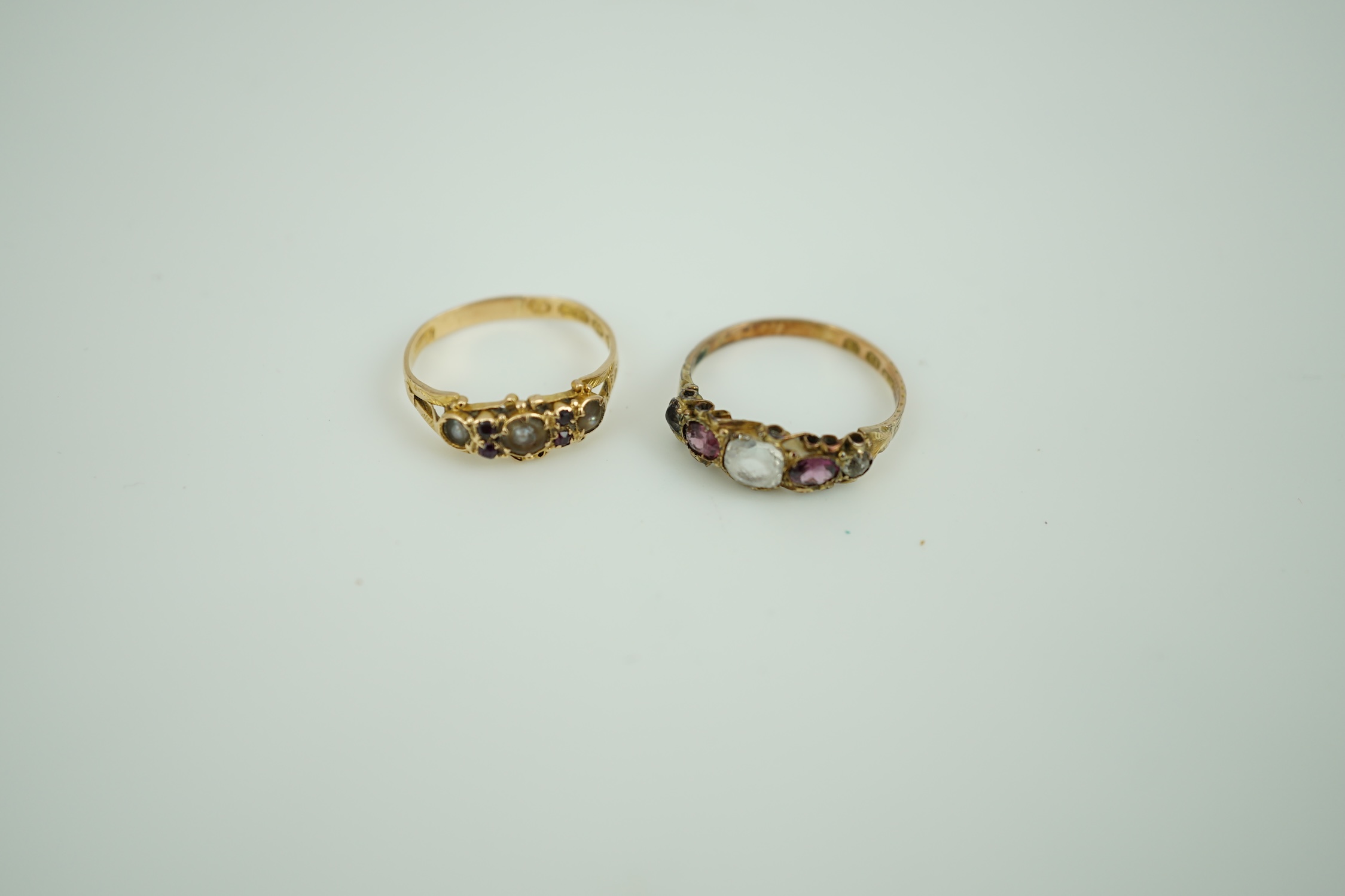 A late Victorian 15ct gold, split pearl and garnet cluster set ring, size N/O and a similar 12ct gold, paste and garnet cluster set ring.